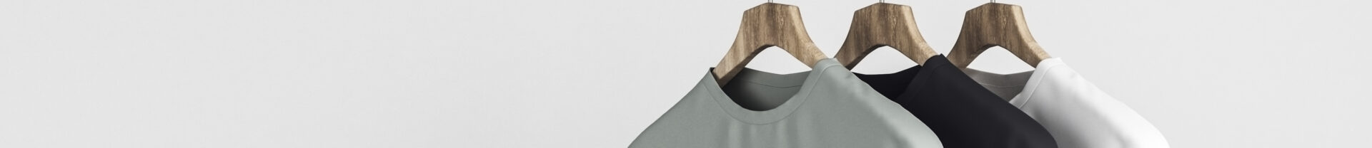 Några t-shirts hänger på en klädställning.
